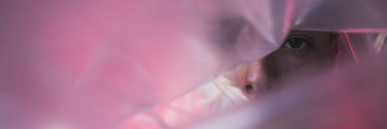 How Maintaining Social Awareness Can Negative Impact Minorities Asian person looking through cellophane