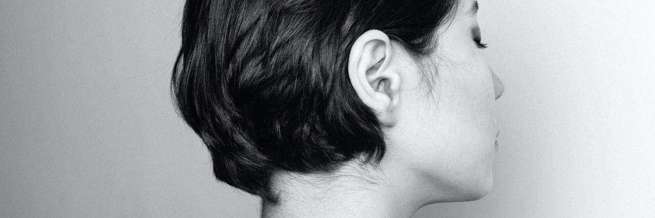 The Phrases That Might Affect You If You Experienced Emotional Neglect black and white photo of a woman looking away from the camera against a blank wall