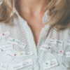 Photo of woman's blouse with notes from to do list pinned to it