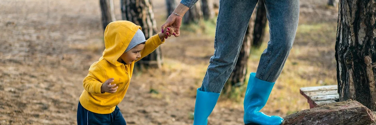 What It Means to Advocate for the Down Syndrome Community Parent helping child walk on a log.