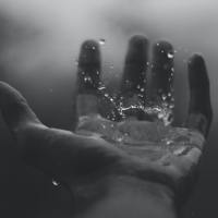 black and white photo of hands under running water