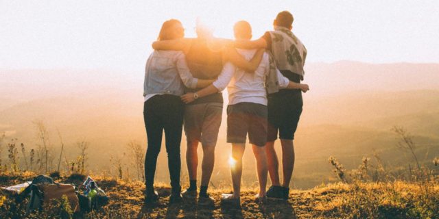 6 Ways You Can Support Sexual Assault Survivors This Sexual Assault Awareness Month photo of four people standing on a cliff at sunset with arms around each other