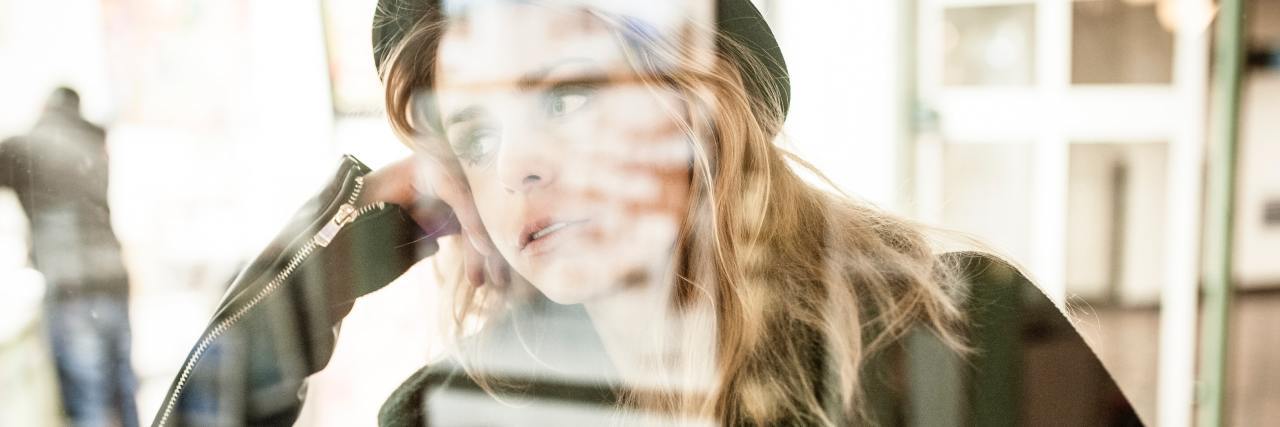 Trauma: Am I a Victim or a Survivor of Childhood Sexual Abuse? blurred photo of a woman reflected in a window lost in thought