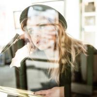 blurred photo of a woman reflected in a window lost in thought