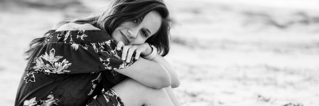 Self-Sabotage: When People Use the Mental Health Term as a Judgment black and white photo of a woman sitting on a beach in the waves