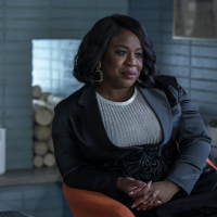 A Black woman leaning back on a chair