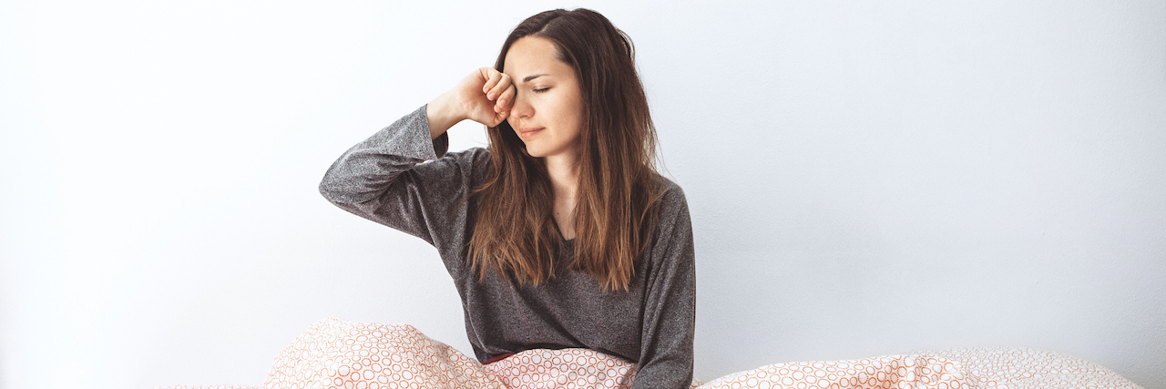 When Mornings Are Tough With Chronic Illness Woman in bed with her hand on her head