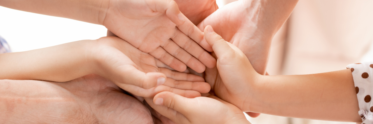 Finding Your Mantra as the Parent of a Child With Hurler Syndrome Hands of family members joined together.