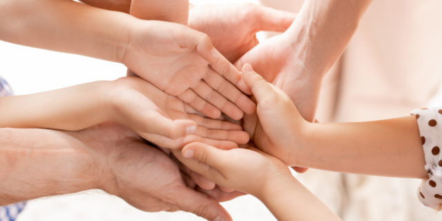 Hands of family members joined together.