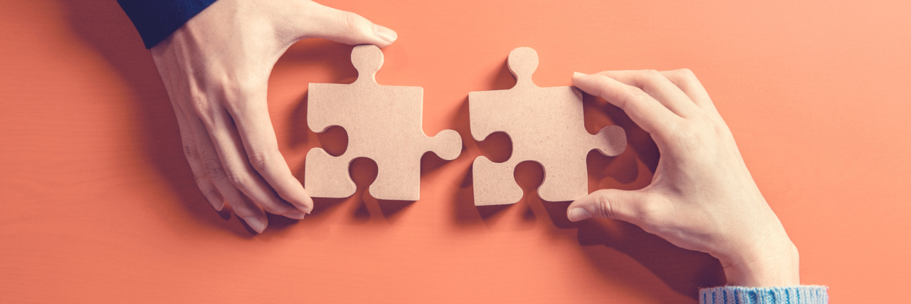 The Analogy My Therapist Used to Help Me Manage My Trauma Responses Two hands each holding a jigsaw puzzle piece next to each other