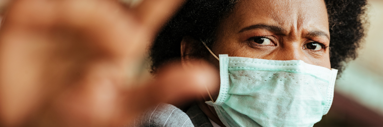 The Problem With the Phrase 'COVID Anxiety Syndrome' woman holding hand up to camera