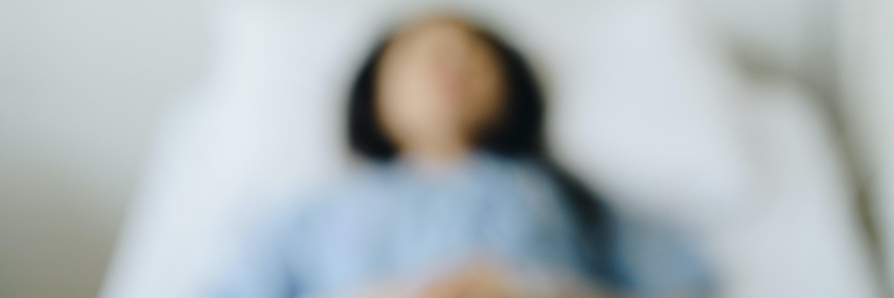 Blurred image of woman lying in hospital bed