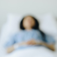 Blurred image of woman lying in hospital bed