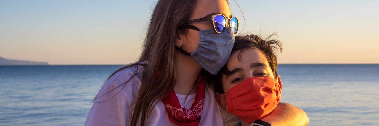 Decision-Making During the Pandemic When Your Child Has a Rare Disease Mother and son wearing masks by the ocean.