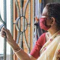 Indian woman looking outside with a mask on