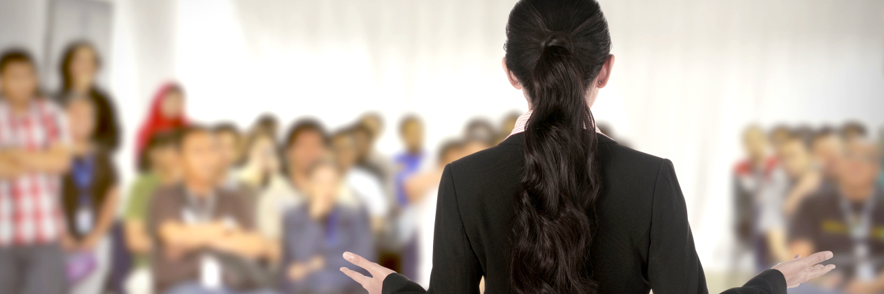 What I Hope Will Change Before the Next Autism Acceptance Month Speaker giving presentation. Audience is listening.