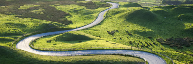 Winding road through a green grassland.