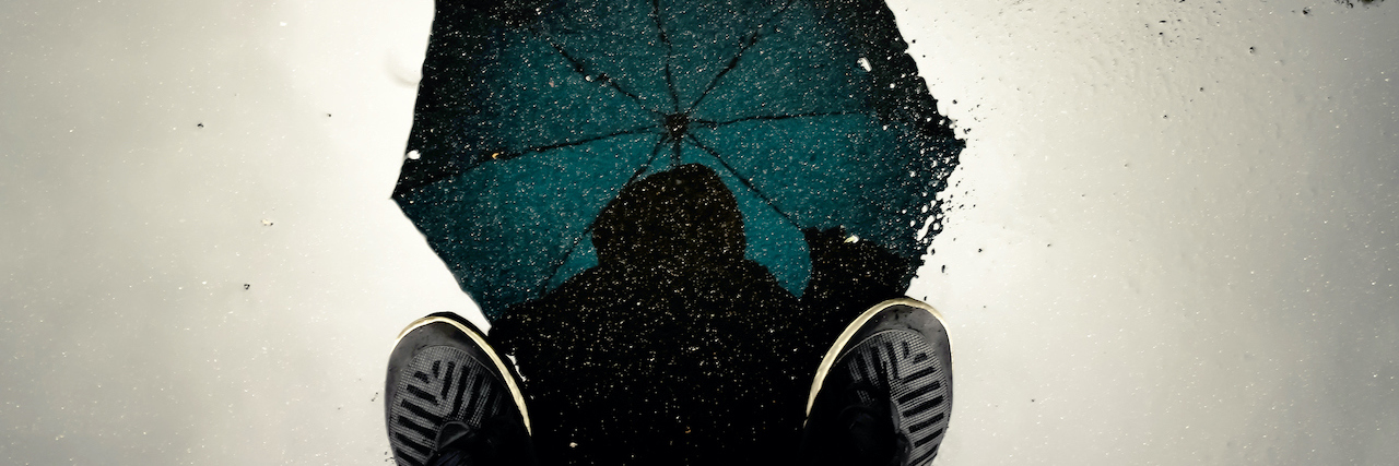 The Many Meanings and Definitions of Trauma Illustration of person standing with umbrella during a storm