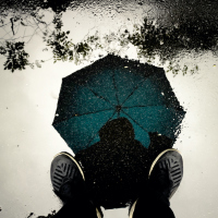 Illustration of person standing with umbrella during a storm