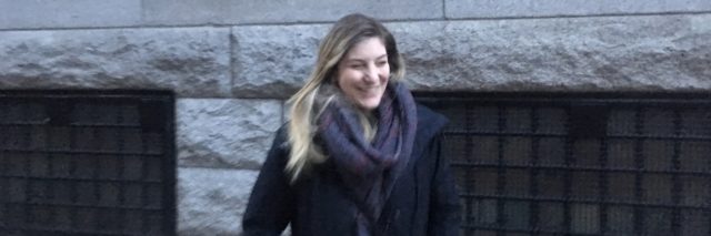 Photo of the contributor smiling and looking to the side, wearing a heavy coat and scarf