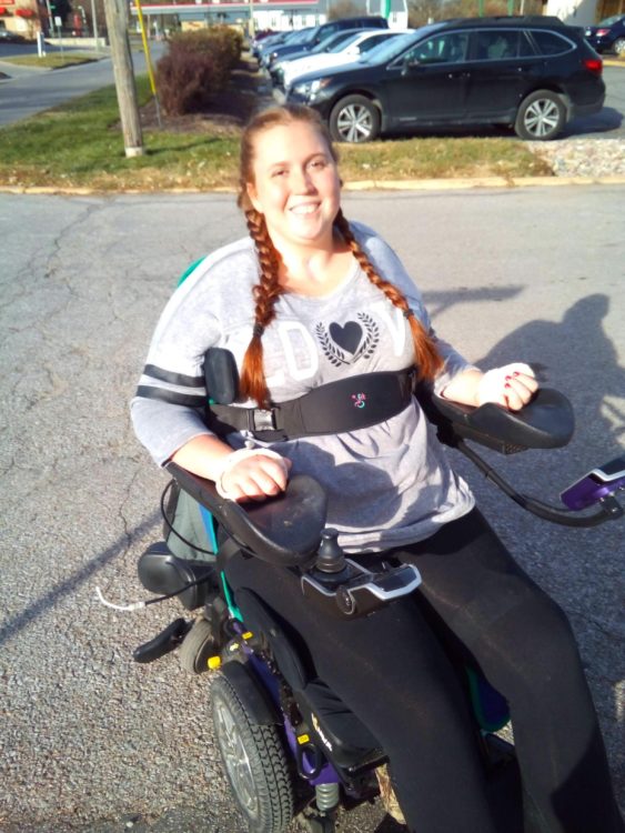 Tiffany outdoors in her power wheelchair.