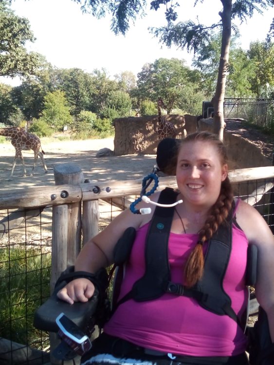 Tiffany sitting in her wheelchair using her mouth control.