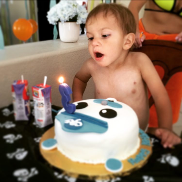 A little boy blowing out his birthday cake candle