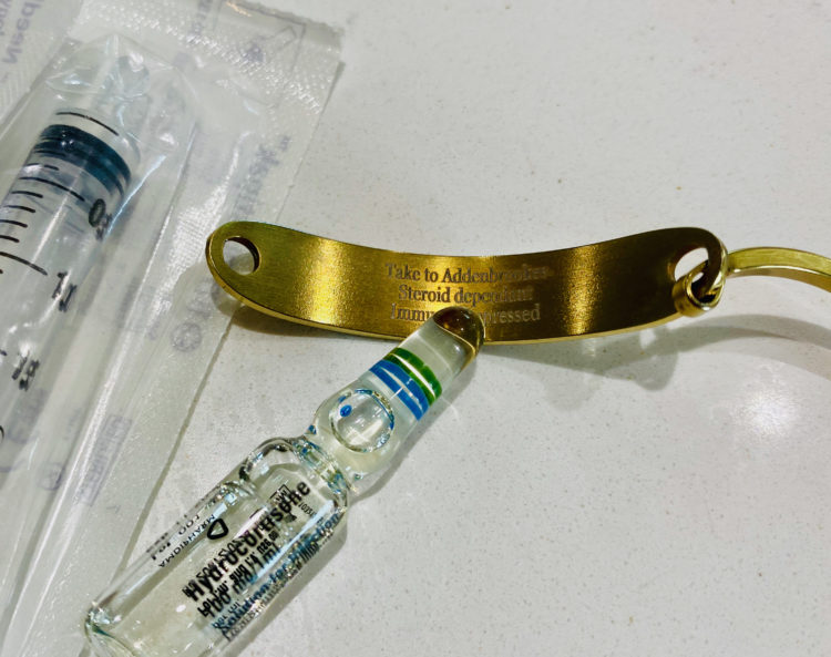Photo of medicine and medical alert bracelet card that says steroid dependent