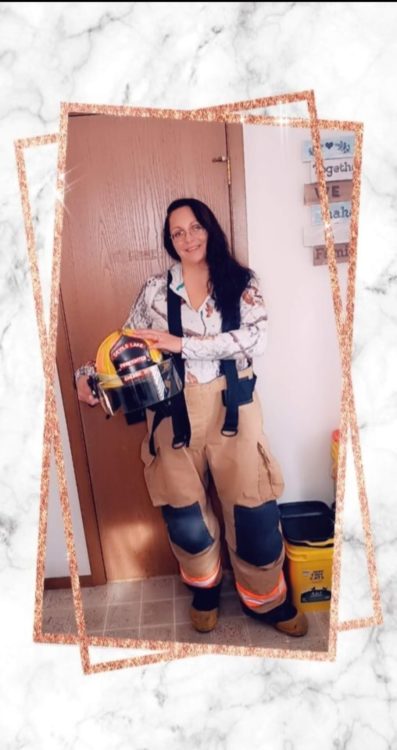 A woman holding a firefighter's helmet