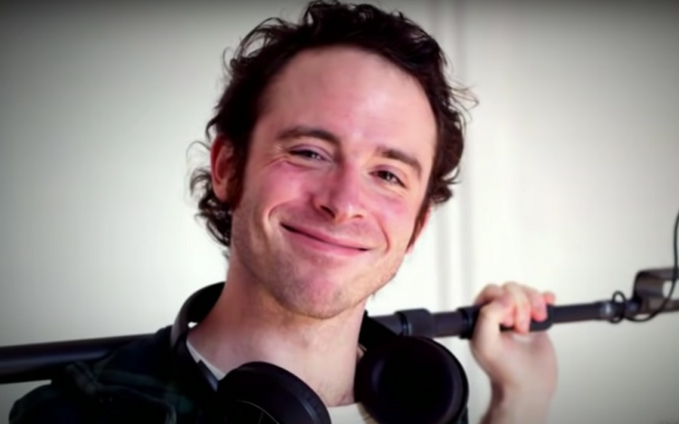 screenshot of sound mixer Michael Wolfe Snyder, smiling for the camera with a mic stand over his shoulders