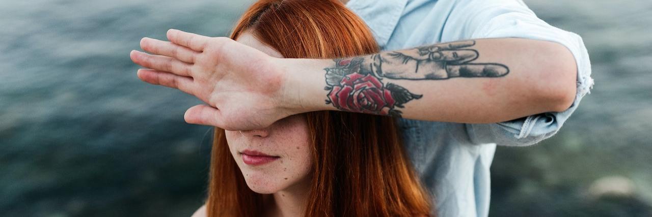 C-PTSD: What Emotional Flashbacks Feel Like A hand blocking a young woman's face