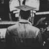 black and white photo taken from behind of a young man with a mortar board, graduation