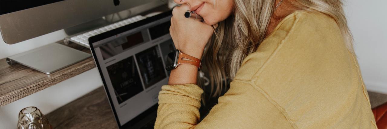 photo of a woman with a computer, thinking