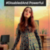 Photo of Sophia a white woman with brown and red hair wearing a blue and green geometric print dress and holding a red cane. She is looking at the camera with pride. In the background is a computer and desk and layered over the photo is a sunset scene. Above her in a black box are the words, “#DisabledAnd Powerful”.
