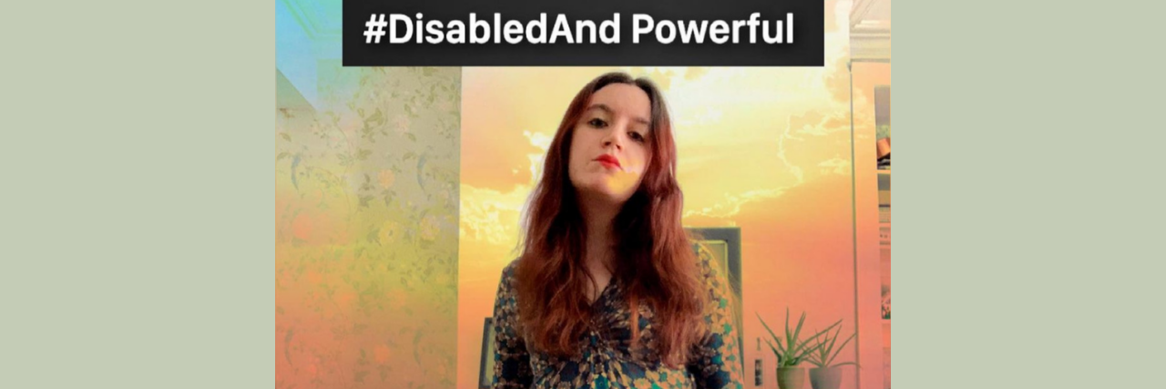 #DisabledAnd Campaign Challenges Misconceptions About Being Disabled Photo of Sophia a white woman with brown and red hair wearing a blue and green geometric print dress and holding a red cane. She is looking at the camera with pride. In the background is a computer and desk and layered over the photo is a sunset scene. Above her in a black box are the words, “#DisabledAnd Powerful”.