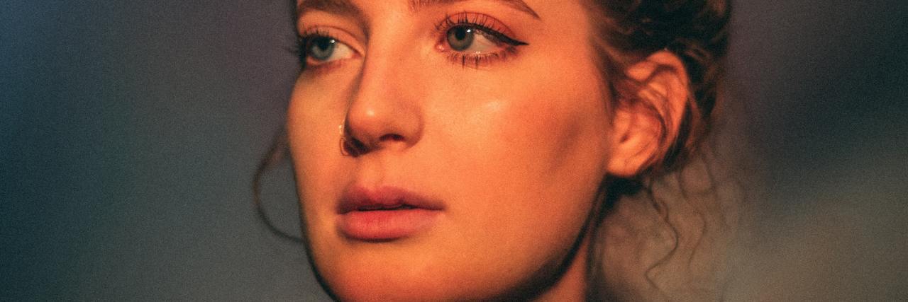 Mental Health: Asking For Help When Everyone Thinks You're Strong photo of a young woman in golden sunset light, crying and looking away