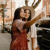 photo of two women taking a selfie together on the street