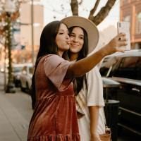 photo of two women taking a selfie together on the street