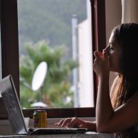 photo of a woman sitting by her window with a laptop
