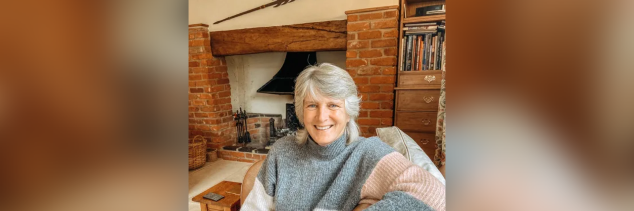 How I Addressed Feeling Lonely in My Neurodiverse Marriage Kerry sitting in front of an old brick fireplace.