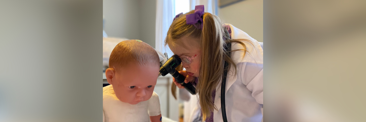 To a Mom Whose Child Just Received a Down Syndrome Diagnosis Kristin's daughter doing a pretend medical exam on her doll.