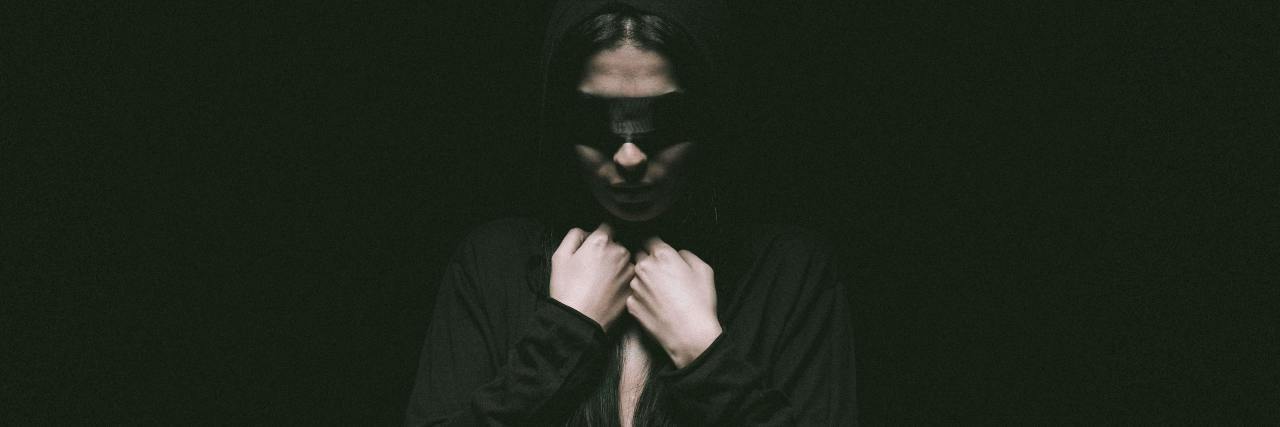 photo of a woman wearing a blindfold and looking distressed