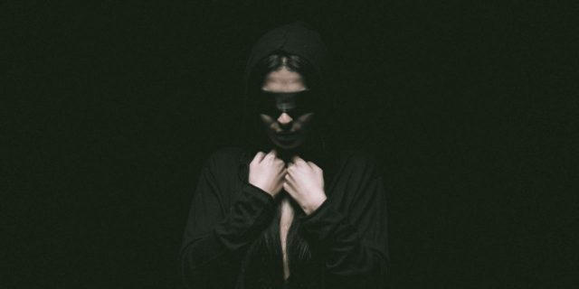 photo of a woman wearing a blindfold and looking distressed