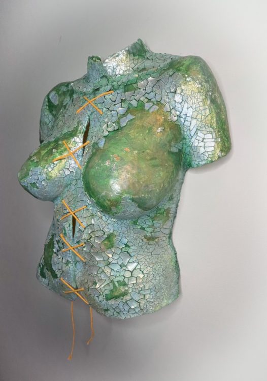  Body cast sculpture "Broken Body": torso in sea green color, covered in shining, cracked silvery pieces. String tied down the middle in a series making an "X" shape (shown from right angle)