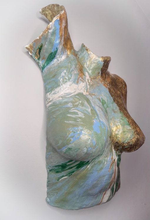 Body cast sculpture "Enduring Spirit" of torso with one side painted in gold and the other in a mix of swirling green, white and blue (shown from left angle)
