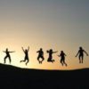 Silhouettes of different people jumping from far away