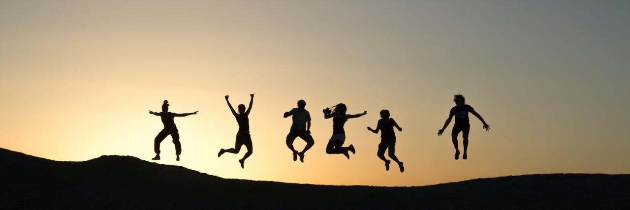 Silhouettes of different people jumping from far away