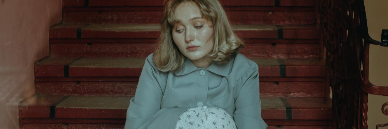 What Eating Disorder Recovery Really Looks Like photo of an upset woman sitting on stairs