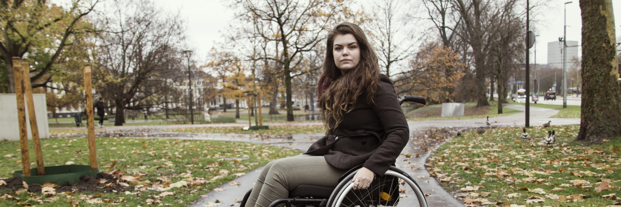 Young woman in wheelchair outside.