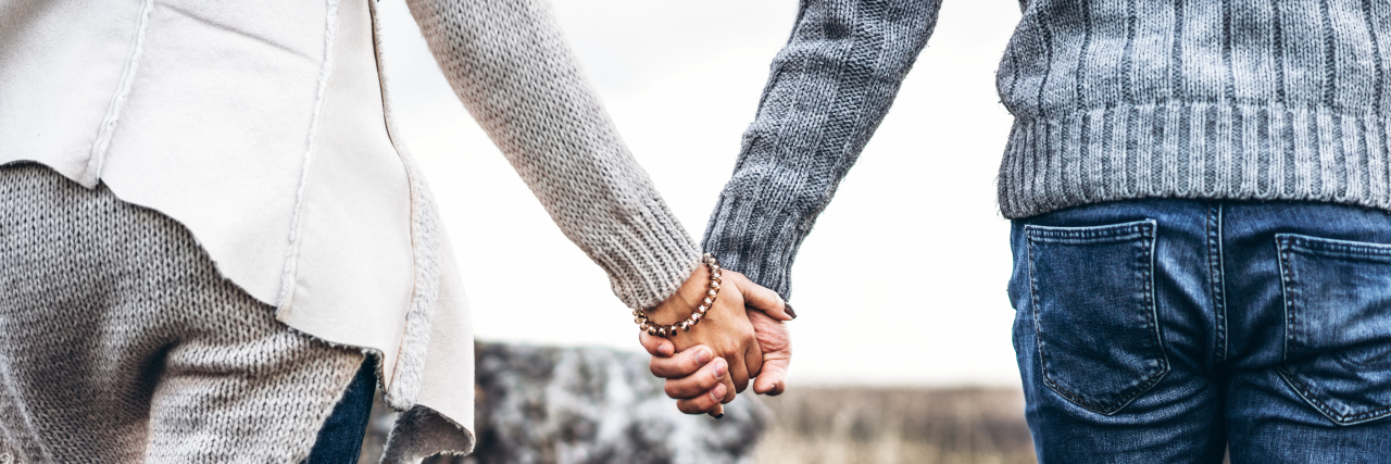 a young couple holding hands outdoors